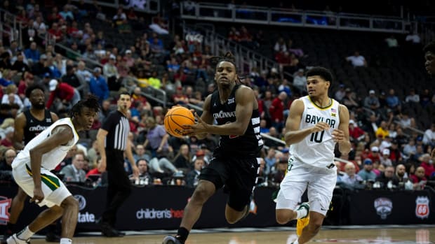 Cincinnati Bearcats guard Jizzle James (2) drives on Baylor Bears guard RayJ Dennis (10) in the second half of the Big 12 Conference tournament game between Cincinnati Bearcats and Baylor Bears at T-Mobile Center in Kansas City, Mo., on Thursday, March 14, 2024.